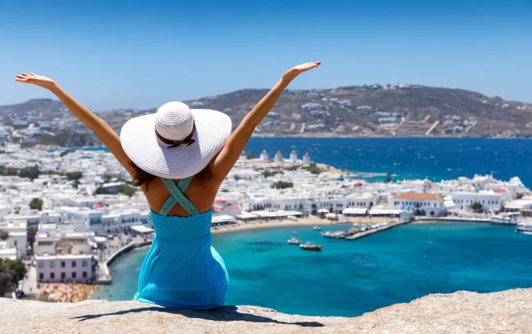 Touristin genießt utsikten över staden Mykonos och är lycklig